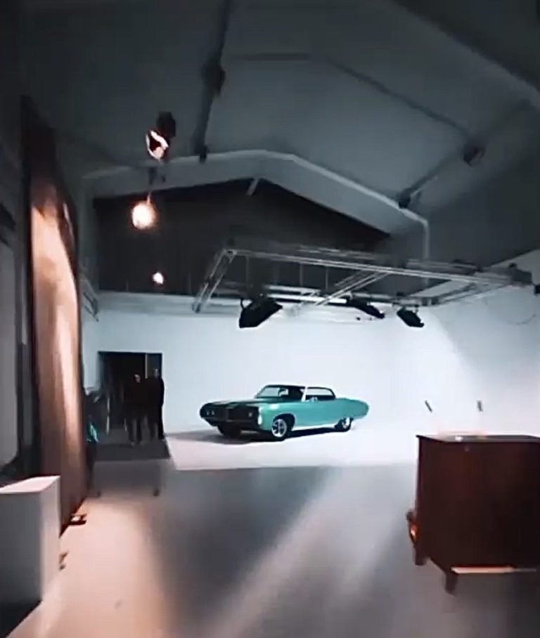 Coche clásico sobre ciclorama blanco iluminado desde el techo