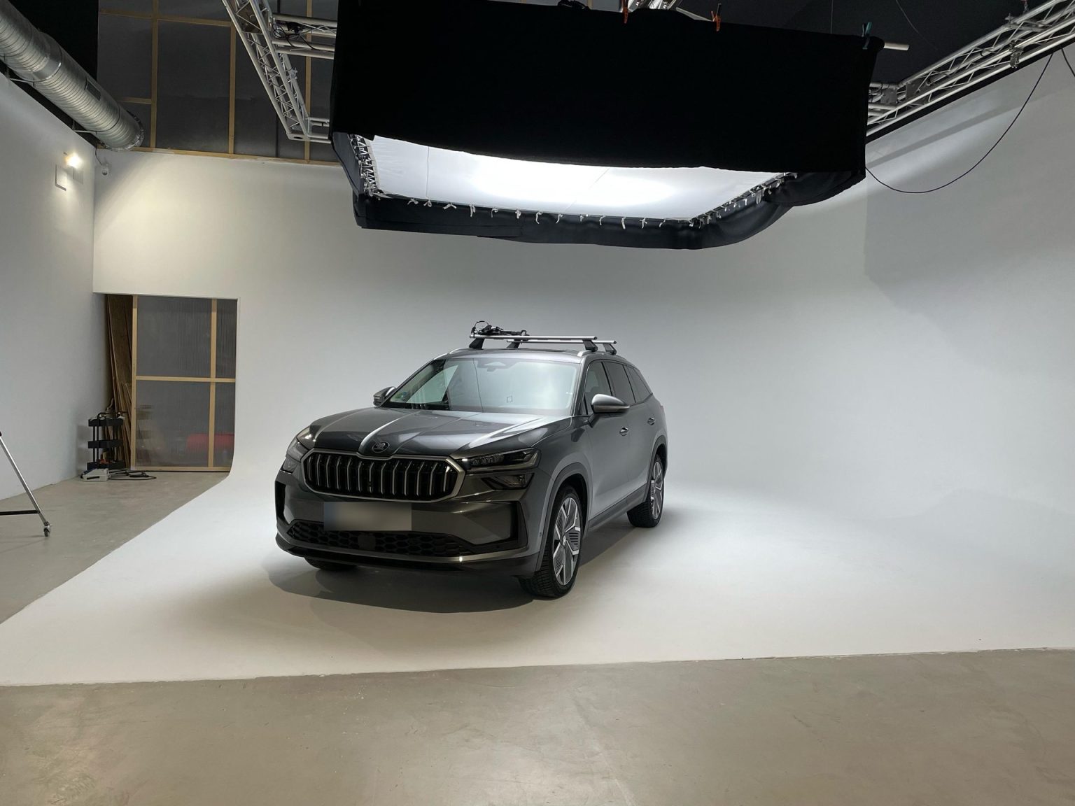 SUV fotografiado en ciclorama blanco bajo caja de luz suspendida
