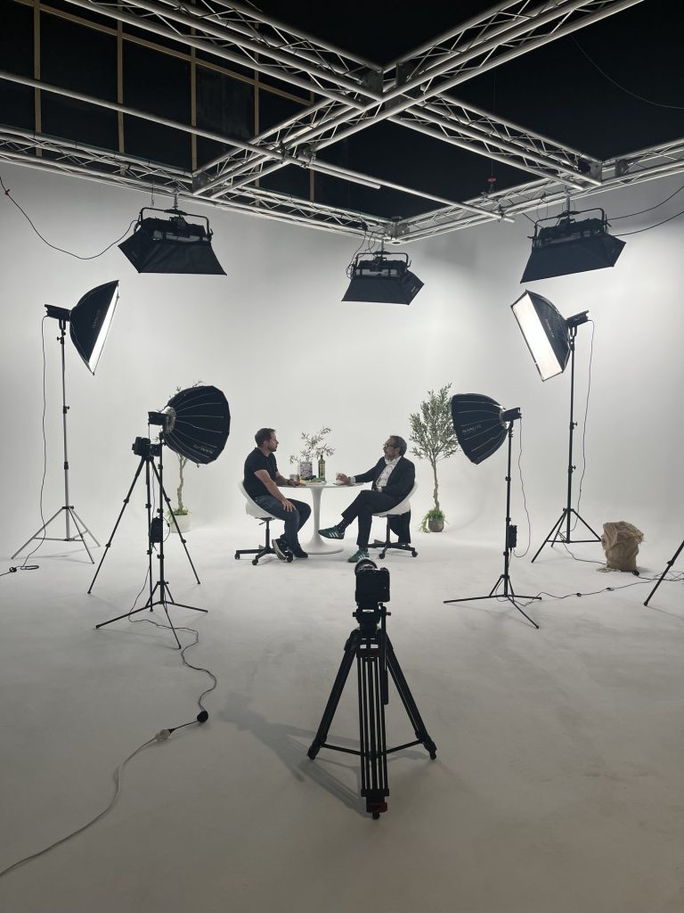 Grabación de entrevista con set de olivos e iluminación LED en ciclorama blanco