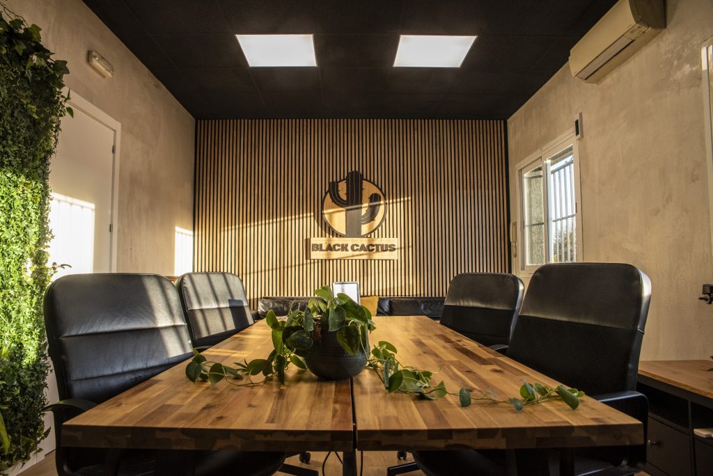 Sala de reuniones con pared vegetal de The Black Cactus Studios