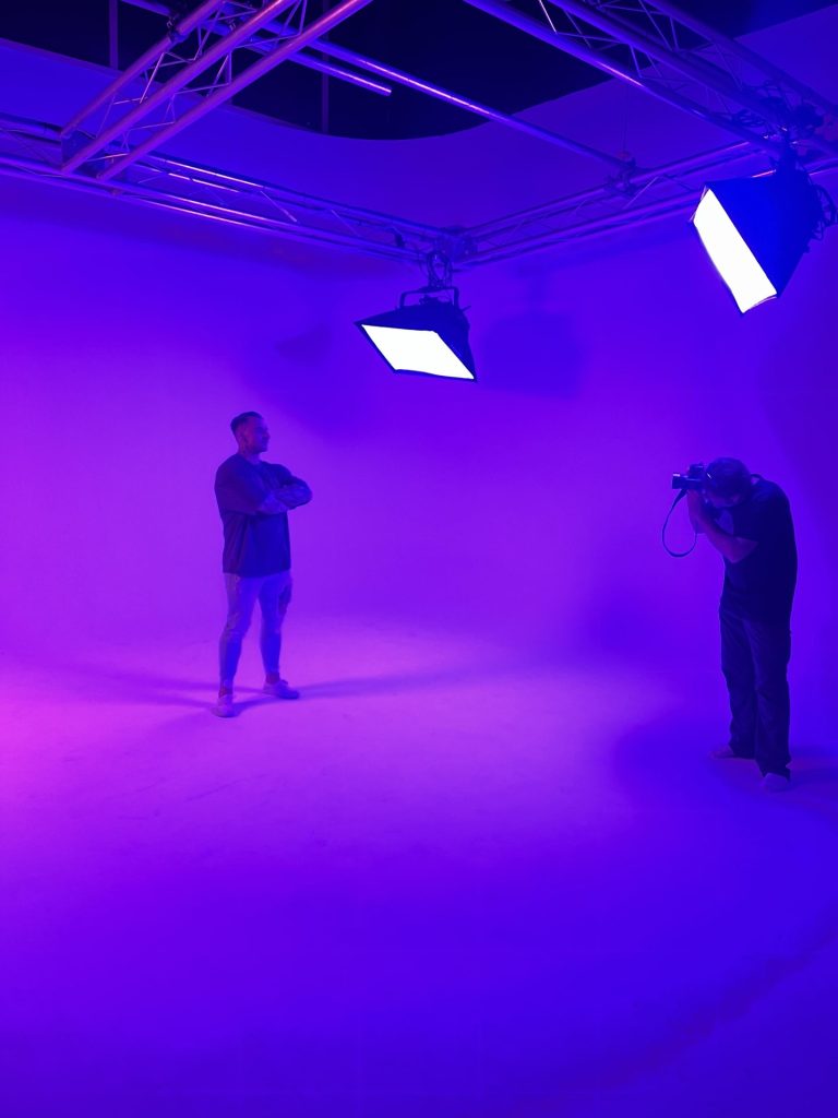 Sesión de fotos en ciclorama blanco iluminado en morado